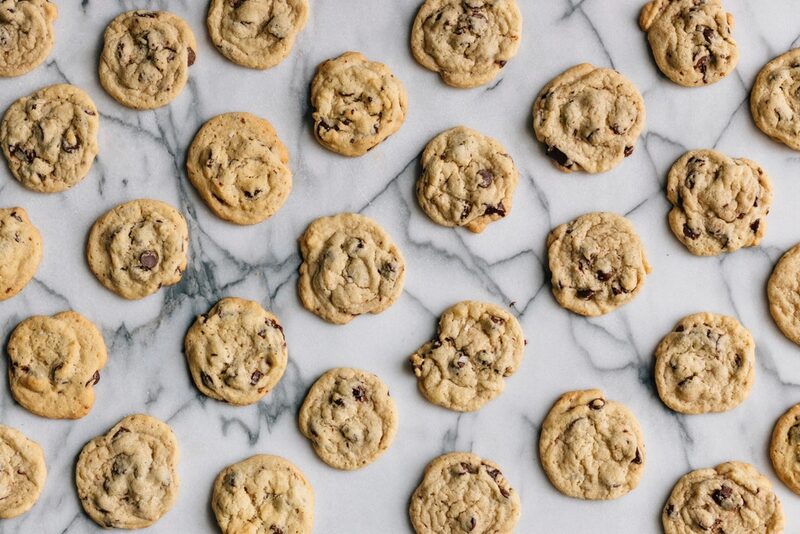 Rows of chocolate chip cookies on a marble surface