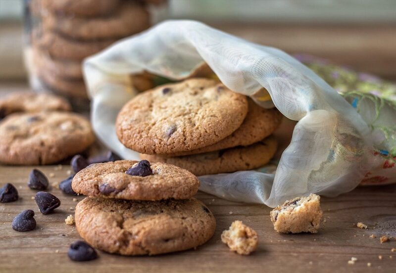 Chocolate chip cookies spilling out of a cloth bag (stock photo)